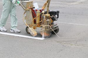 Worker painting parking lot.