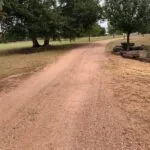 unpaved rural dirt driveway before asphalt paving installation