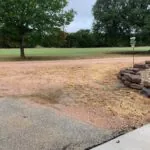 worn asphalt driveway with dirt encroachment needing repair