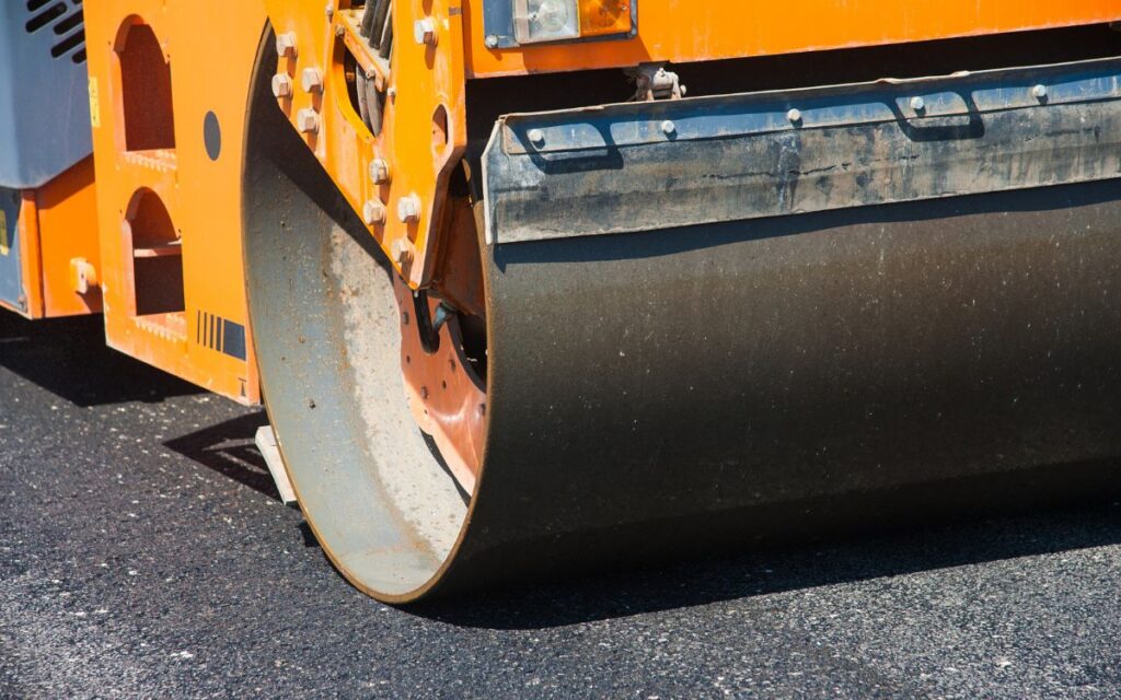 Crew installing hot mix asphalt at the proper paving temperature for long lasting commercial pavement performance