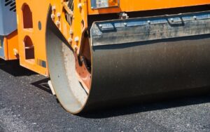 Crew installing hot mix asphalt at the proper paving temperature for long lasting commercial pavement performance