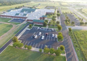 Image of a freshly paved parking lot with a few cars parked in it
