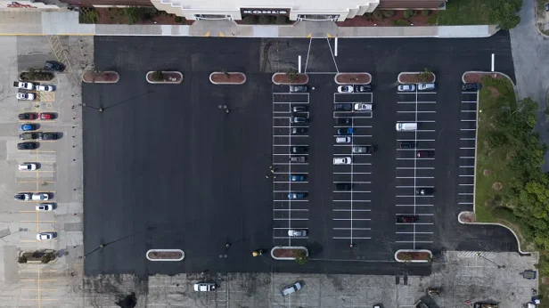 Aerial view of freshly paved and striped commercial parking lot completed by Alpha Paving in Texas
