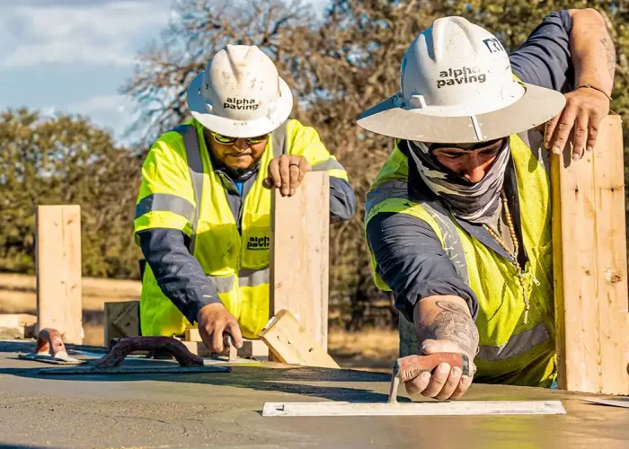 two workers smoothing concrete