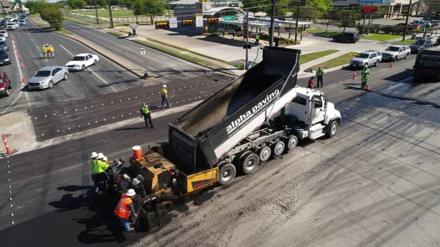 Alpha Paving Industries truck in Texas intersection performing paving services