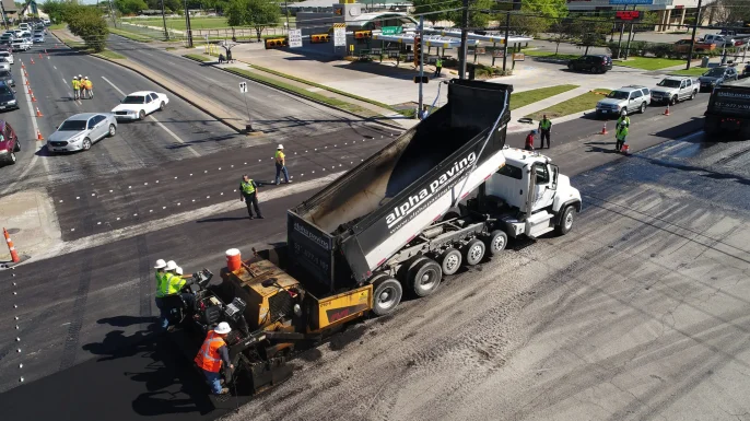 Alpha Paving Industries truck in Texas intersection performing paving services