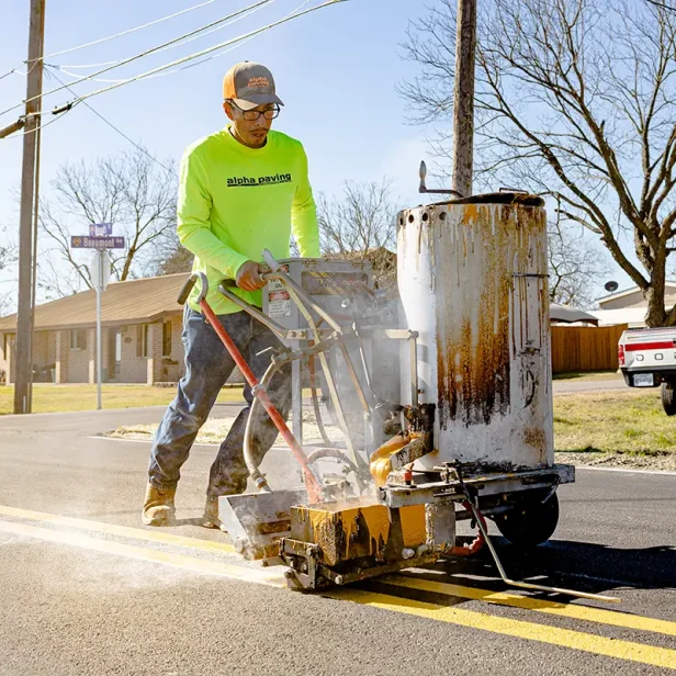 alpha paving employee applying thermoplastic