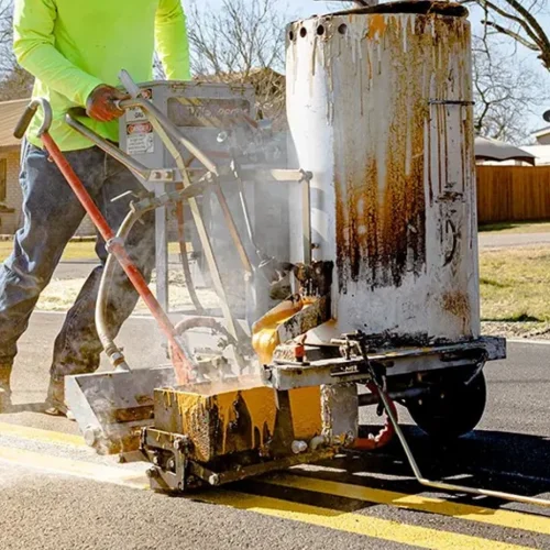 Pavement marking contractor applying traffic line striping on asphalt roadway